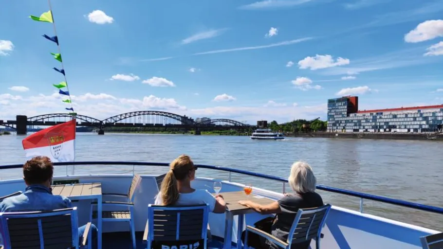 Three people relax on a cruise ship deck.