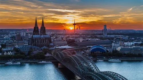 Cathedral and bridge over river at sunset.