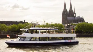 Boot auf Fluss mit Kathedrale im Hintergrund.