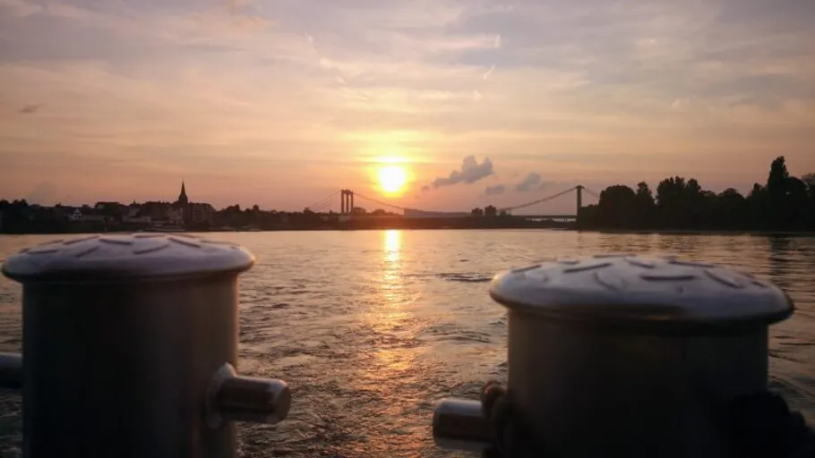 Sunset over a river with distant bridge.