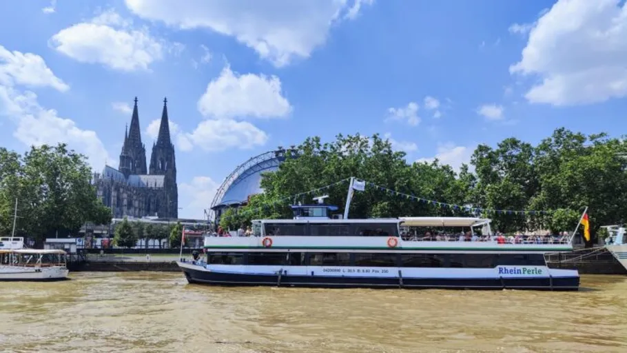 Boat sailing on river with cathedral background.