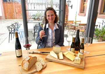 Woman enjoying cheese and wine in a restaurant.