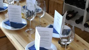 Tisch gedeckt mit Gläsern, Menüs und Servietten.