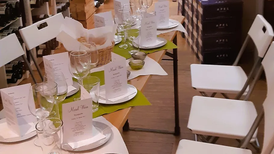 Tisch mit Weingläsern und Menüs gedeckt.