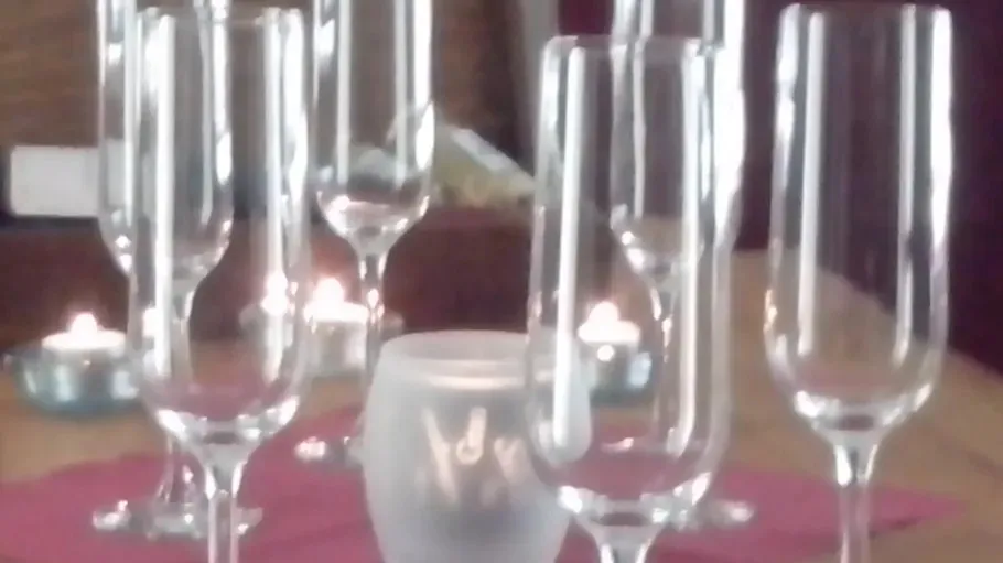 Champagne glasses on a table with candles.
