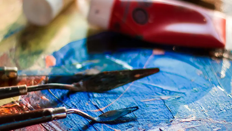 Palette knives and paint on colorful canvas.