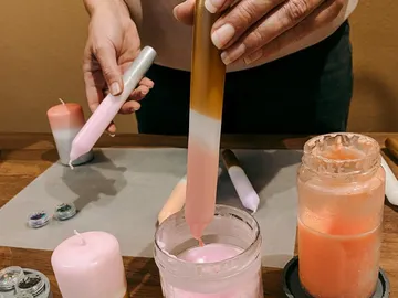 Kerzen werden hergestellt, während Farben und Materialien verwendet werden.