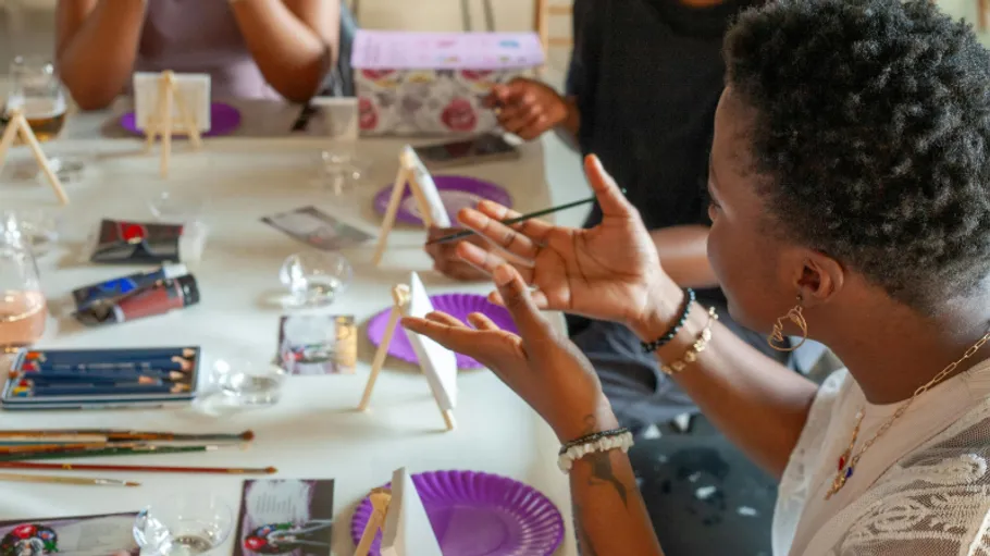 People painting at a table in a workshop.