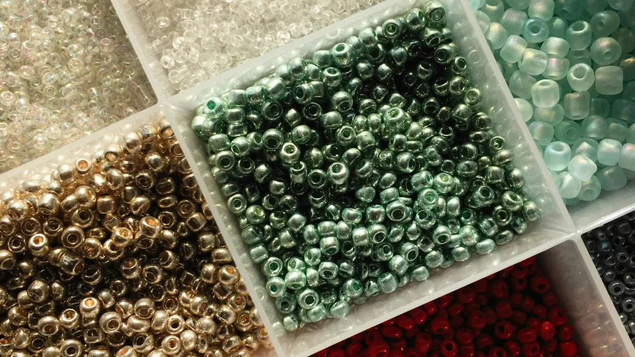 Colorful beads sorted in separate containers.