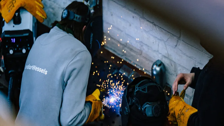 Welder working with sparks flying indoors.