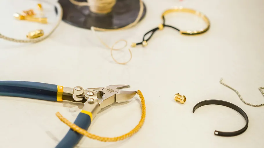 Jewelry-making tools and materials on table.