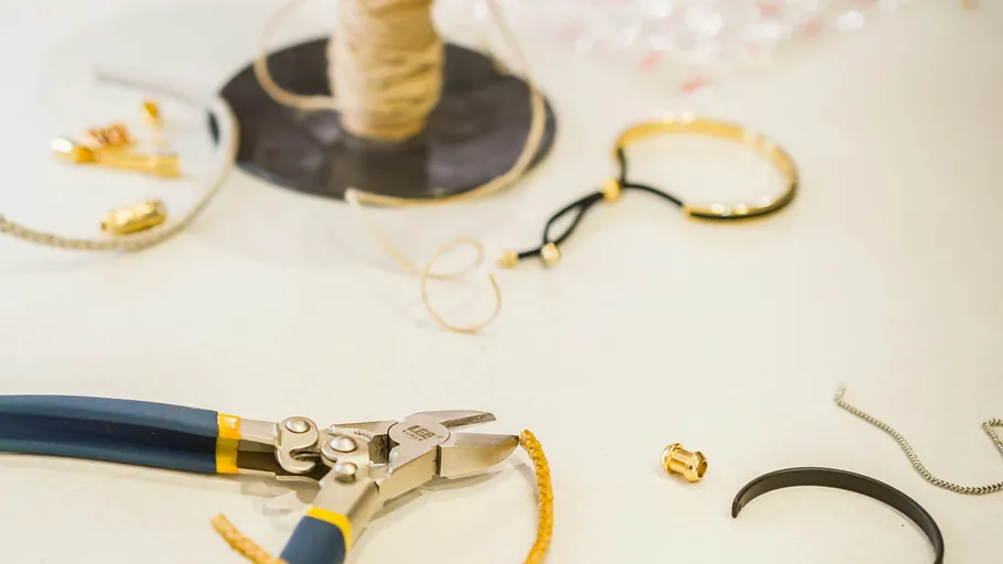 Jewelry tools and materials on crafting table.