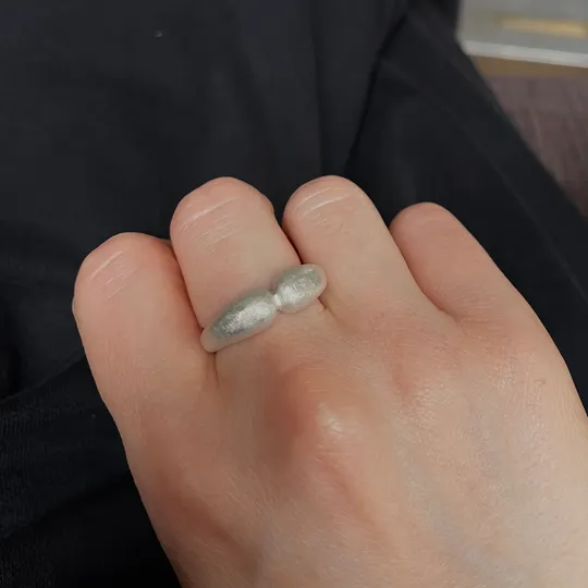 Hand wearing a silver ring on thumb.