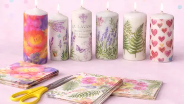 Dekorative Kerzen mit Blumenmustern und Schere daneben.