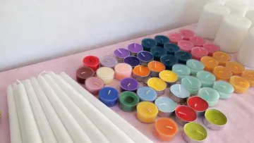 Bunte Kerzen auf einer rosa Fläche.
