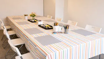 Table set with art supplies in bright room.