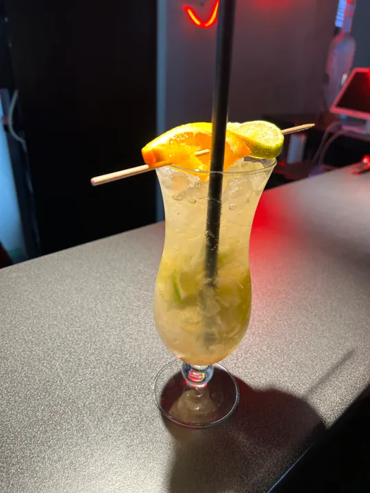 Cocktail mit Orange und Limette auf Bartheke.