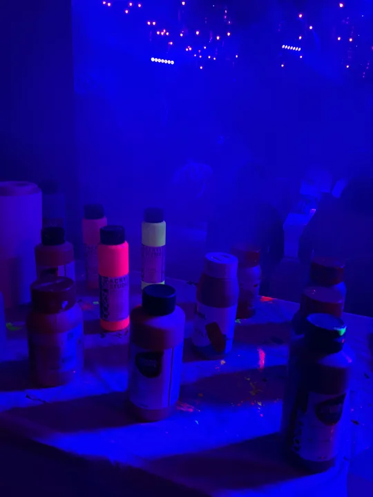 Farbflaschen unter blauem UV-Licht.
