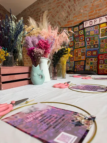 Blumenarrangement-Tisch mit getrockneten Blumen und Werkzeugen.