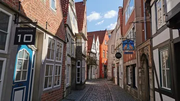 Schmale Kopfsteinpflasterstraße mit historischen Gebäuden.