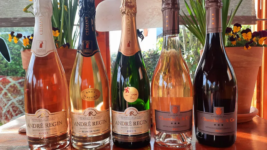 Fünf Weinflaschen auf einem Holztisch.