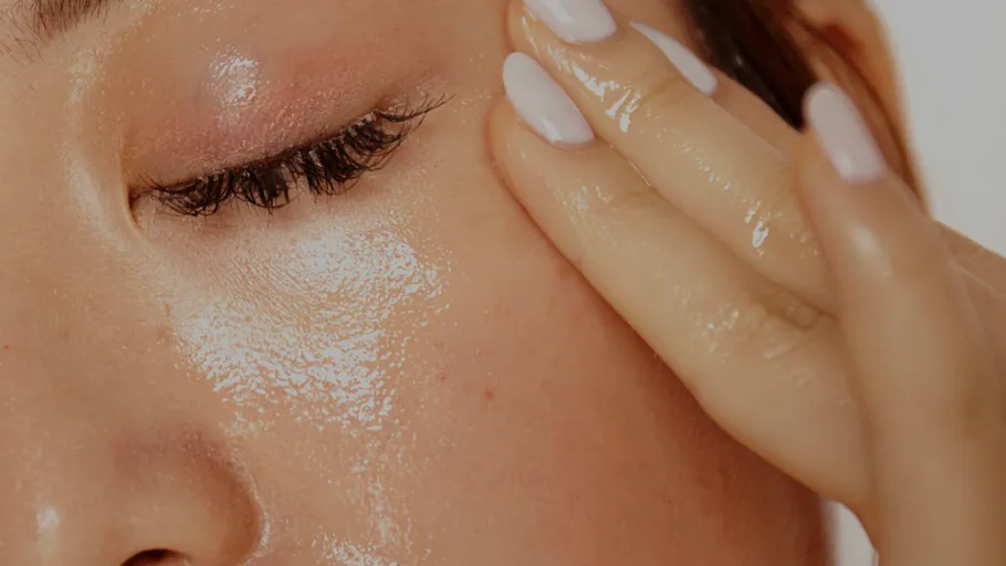 Close-up of a shiny face with hand touching.