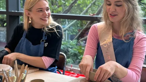 Two women crafting pottery indoors.