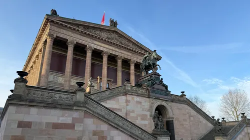 Klassisches Gebäude mit Statuen und blauem Himmel.