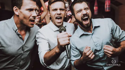 Drei Männer singen begeistert ins Mikrofon.