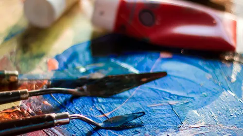 Spachtel mit blauer Farbe und Tube.