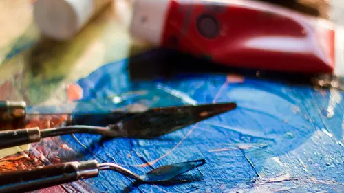 Palette knives on colorful painted canvas.