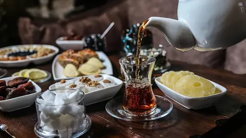 Tea being poured with breakfast food.