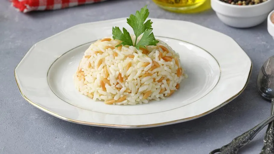 Reis-Pasta-Pilaw auf weißem Teller.