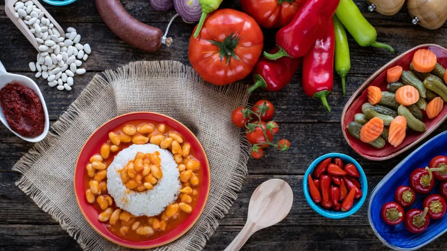 Rice and beans surrounded by vegetables and spices.