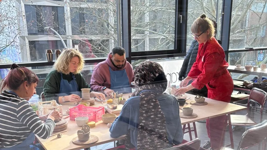 People crafting pottery in a bright studio.