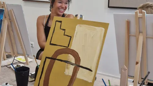 Woman smiling near abstract painting in studio.