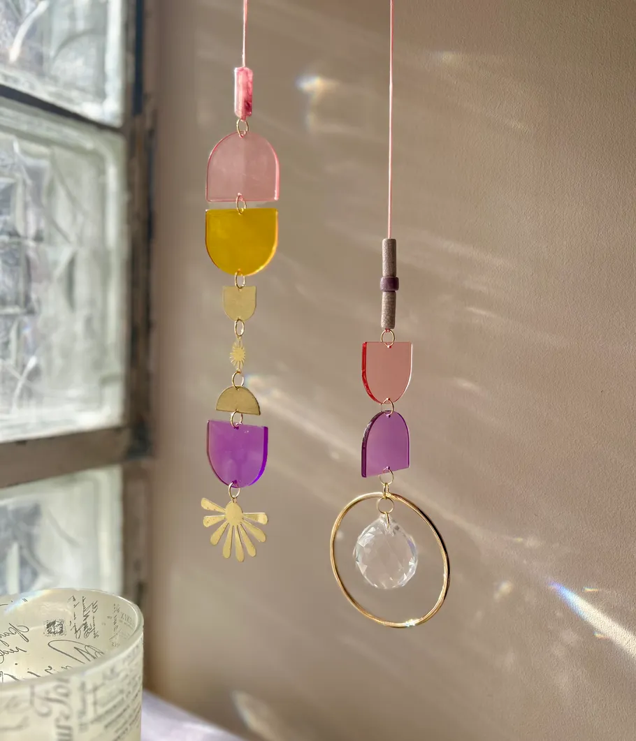 Bunte Sonnenfänger hängen nahe einem Fenster.