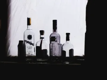Bottles stand in backlight against a white background.