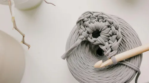 Gray yarn and crochet hook on table.