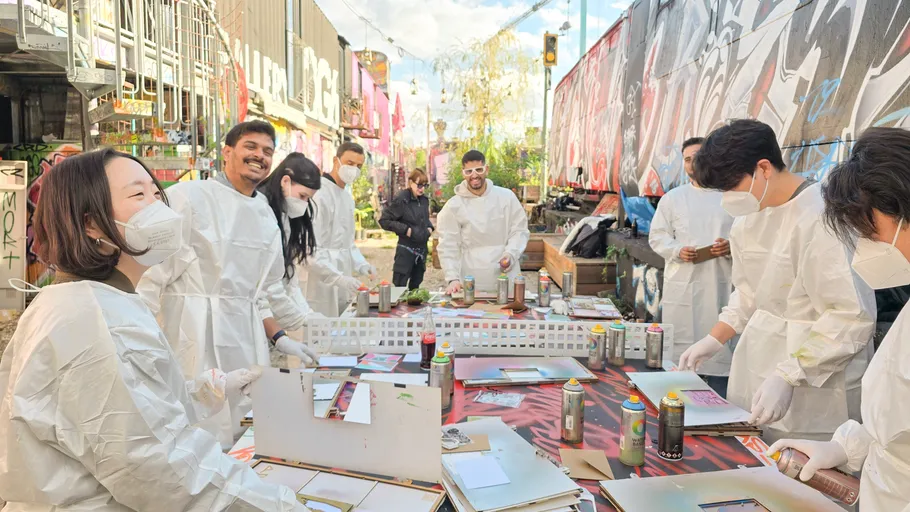 Gruppe sprüht Kunst in städtischem Graffiti-Gebiet.