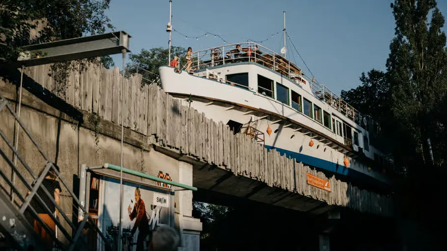 Boat placed on a bridge with trees around.