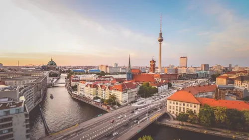Cityscape with TV tower and river at sunset.