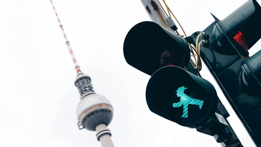 Green pedestrian light with tower background.