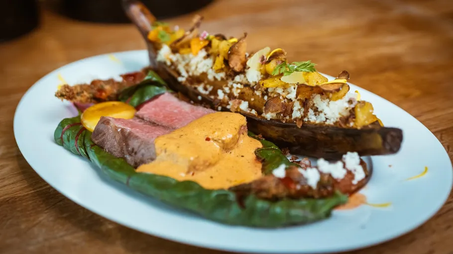 Gourmetgericht mit gefüllter Aubergine und Soße.