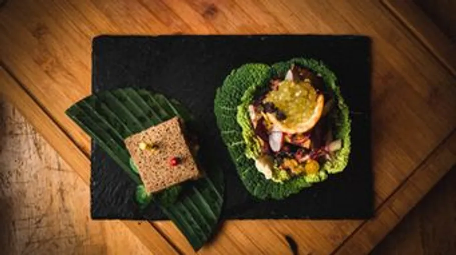 Gourmet dish on slate and wooden table.