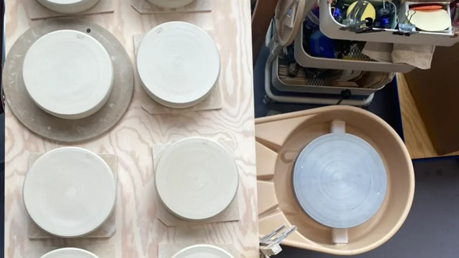 Pottery wheels and tools in a workshop.