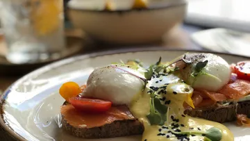 Eggs Benedict with salmon on plate in cafe.