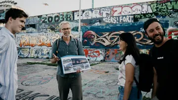 Group of people with book in graffiti area.
