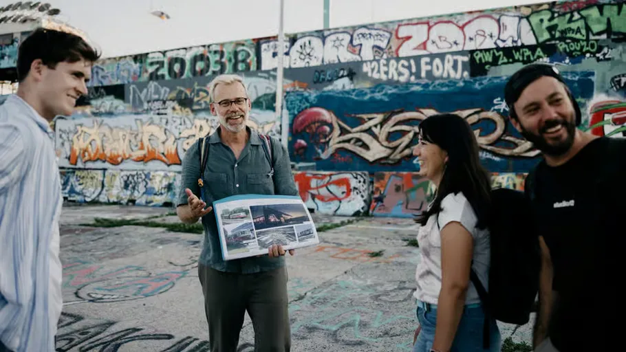 Gruppe von Menschen mit Buch in Graffitibereich.