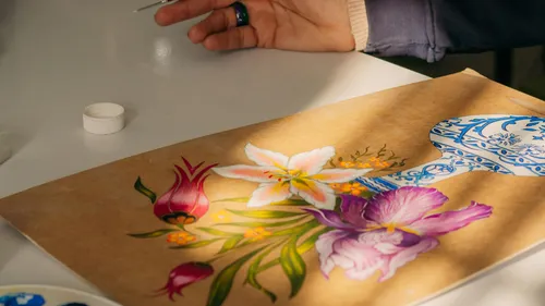 Hand painting floral design on brown paper.